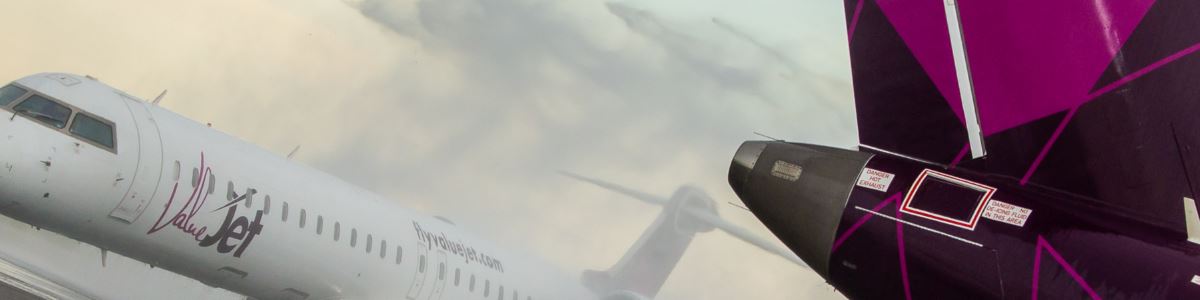 A ValueJet aircraft taking off beside the tail of another ValueJet jet